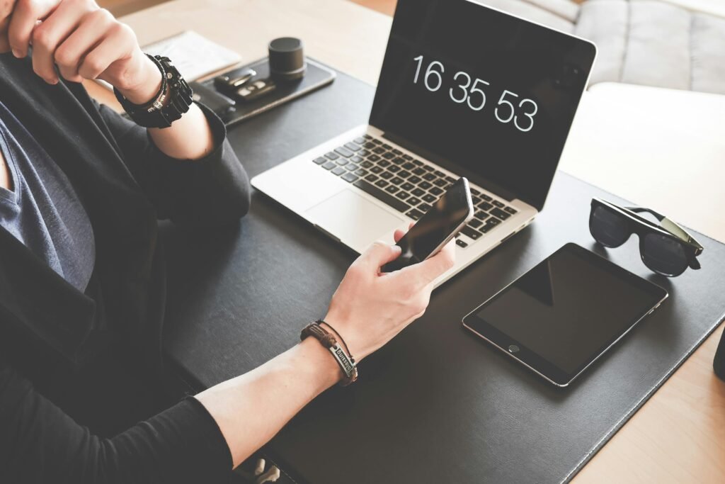 A modern workspace featuring a laptop, smartphone, tablet, and sunglasses, illustrating digital connectivity.